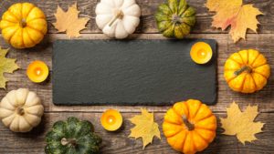 Thanksgiving background with pumpkins, autumn leaves and candles