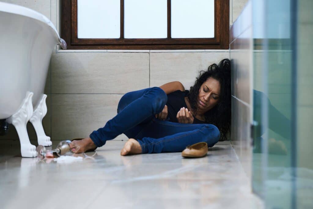 Dependent on drugs. Shot of a drug addict passed out on the bathroom floor.